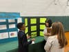 : Nile J., Grade 8, presenting his project “The Science of Boredom” to two judges from the Cold Spring Harbor Laboratory, Dr. Diane Esposito and Ms. Laura Lynn.