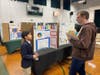 Blake D., Grade 5, explaining his project titled “Does Age Affect Multitasking” to judge Dr. Brian A Kinney.
