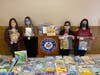 From L to R: Landing Elementary School teachers Jaime Bouretis, Christiana Nicolau, Landing principal Alexa Doeschner and reading teacher Melanie Odone in front of a table full of books for the students to choose from. 