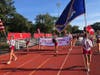 Glen Cove High School varsity cheerleaders lead the marchers carrying their school’s banner as they enter the field.