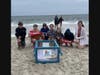 North Country Road Middle School science club students bring Peachy Keen down to the shoreline in preparation for his release back into the ocean following his rehabilitation