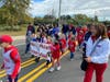 Students from Miller Place School District’s Andrew Muller Primary School represent their school and make their way to the football field.