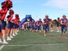 Miller Place High School’s varsity football team makes their way onto the field while being cheered on by the cheerleaders.
