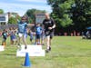 Harry Morris, of the Long Island Rough Riders, ran alongside a student during a hurdling relay. 