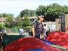 Physical Education Teacher Mark Checola cheered with students as they shook a rainbow parachute up and down. 