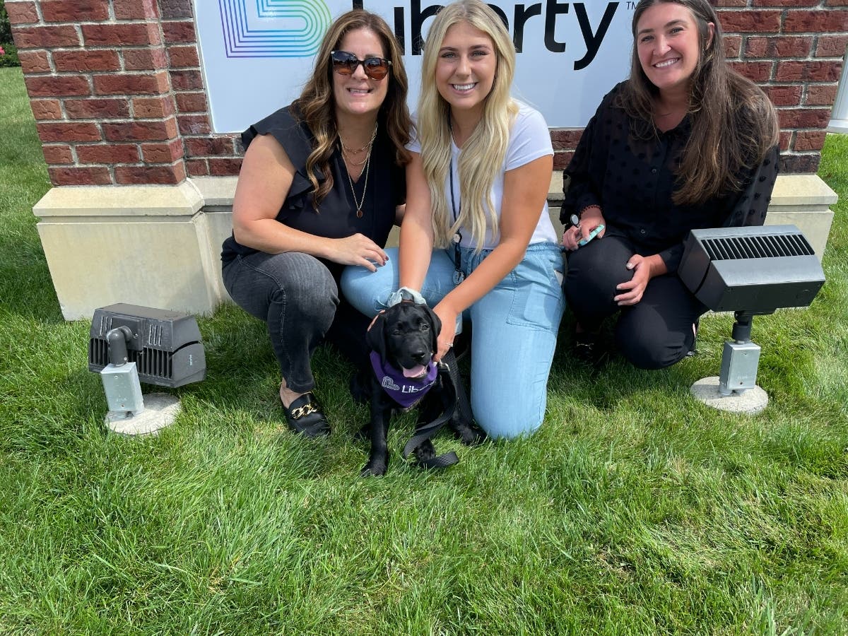 (L-R): Sweeney, Liberty’s Puppy With a Purpose® is getting to know his Liberty family. On his first day at the office, he posed for photos with Liberty New York Water employees Michelle Serravillo, Claudia Wagner and Laura Kaempf.