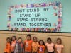  Lawrence Primary School standing in front of their Unity Day bulletin board and wearing orange
