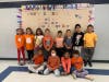  Lawrence Primary School standing in front of their Unity Day bulletin board and wearing orange
