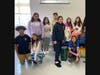  Lawrence Middle School Service-Learning Club members with the donated Thanksgiving dinner bags
