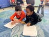 The students helped each other fill in missing details and ensure clarity in their writing. 