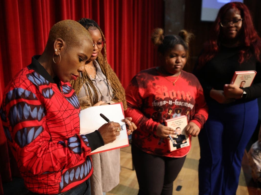 Luvvie Ajayi Jones signs copies of her book Rising Troublemaker