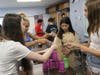 Students were tasked with stacking cups using only a rubber band and strings.