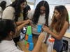 Students were tasked with stacking cups using only a rubber band and strings.