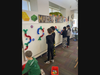 Students use the magnetic wall to build paths with tubes.