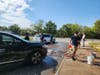  Lawrence High School seniors washing cars at their fundraiser
