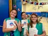 Girls Scouts hold programs for the Riley Avenue Elementary School Flag Day ceremony.