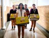 The Sophomore members of Student Council (STUCO) carry boxes of food to the loading dock.