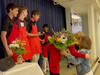 Zein receiving flowers from her teenage helpers after she cooked for 100 people to raise $41,000
