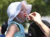 One-year-old Katie Strobel enjoys ice cream served by her mom while perched on her dad's shoulders during Napa Porchfest, Sunday, July 28, 2019.