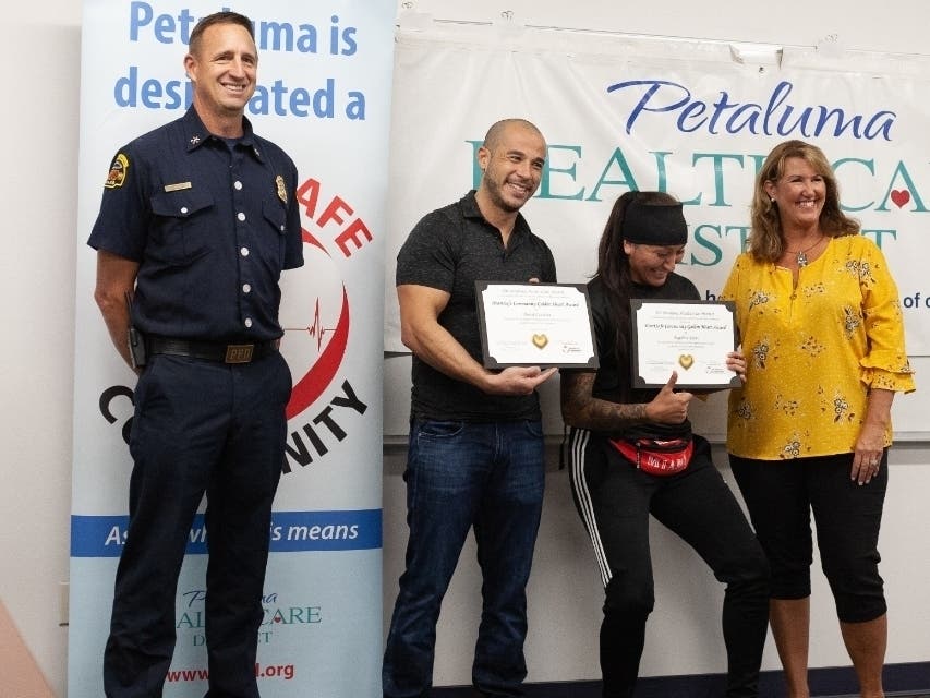 GOLDEN HEART AWARDS: Angelica Rivas and David Cassetta (center) receive awards Sept. 26, 2019, from Assistant Petaluma fire Chief Jeff Schach and Tami Bender, with Petaluma Health Care District.