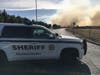 A Solano County Sheriff's patrol car blocks a roadway as smoke billows from a brush fire around 5 p.m. Friday at McGary, Red Top and Lopes roads in Fairfield.