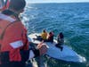 A U.S. Coast Guard crew from Bodega Bay rescues three from a capsized boat Monday morning near Tomales Bay. The trio of fishermen sat on the boat's hull until help arrived.