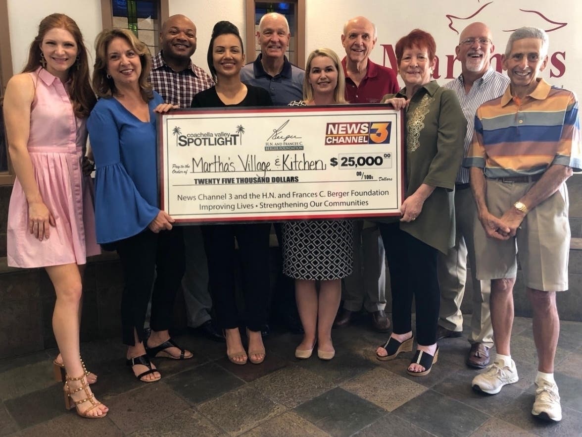 Catharine Reed, of H.N. and Frances C. Berger Foundation, and Caitlin Thropay, of News Channel 3, present a $25,000 Coachella Valley Spotlight grant to Linda Barrack, president of Martha’s Village and Kitchen, with staff, volunteers and and board members.