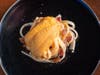 Chīsai Sushi Club's Uni Carbonara: fresh udon noodles served with bacon and an uni cream sauce with cracked black pepper and raw uni.