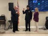 Trustee John Delany administers the oath of office to Police Officer Thomas Imperatore as his mother, Joanne Courtade, looks on.