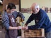A student builds a custom shoe rack during a free program at The Bridge Teen Center with the help of volunteers from Operation Nehemiah. 