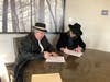 Singer Jim Mitchell (right), signs a contract with John Austin Mulhern, president of DDF JAM Publishing, LLC.