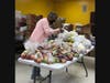 Neighbors Helping Neighbors volunteer Claire Kelly bags food donations for distribution.