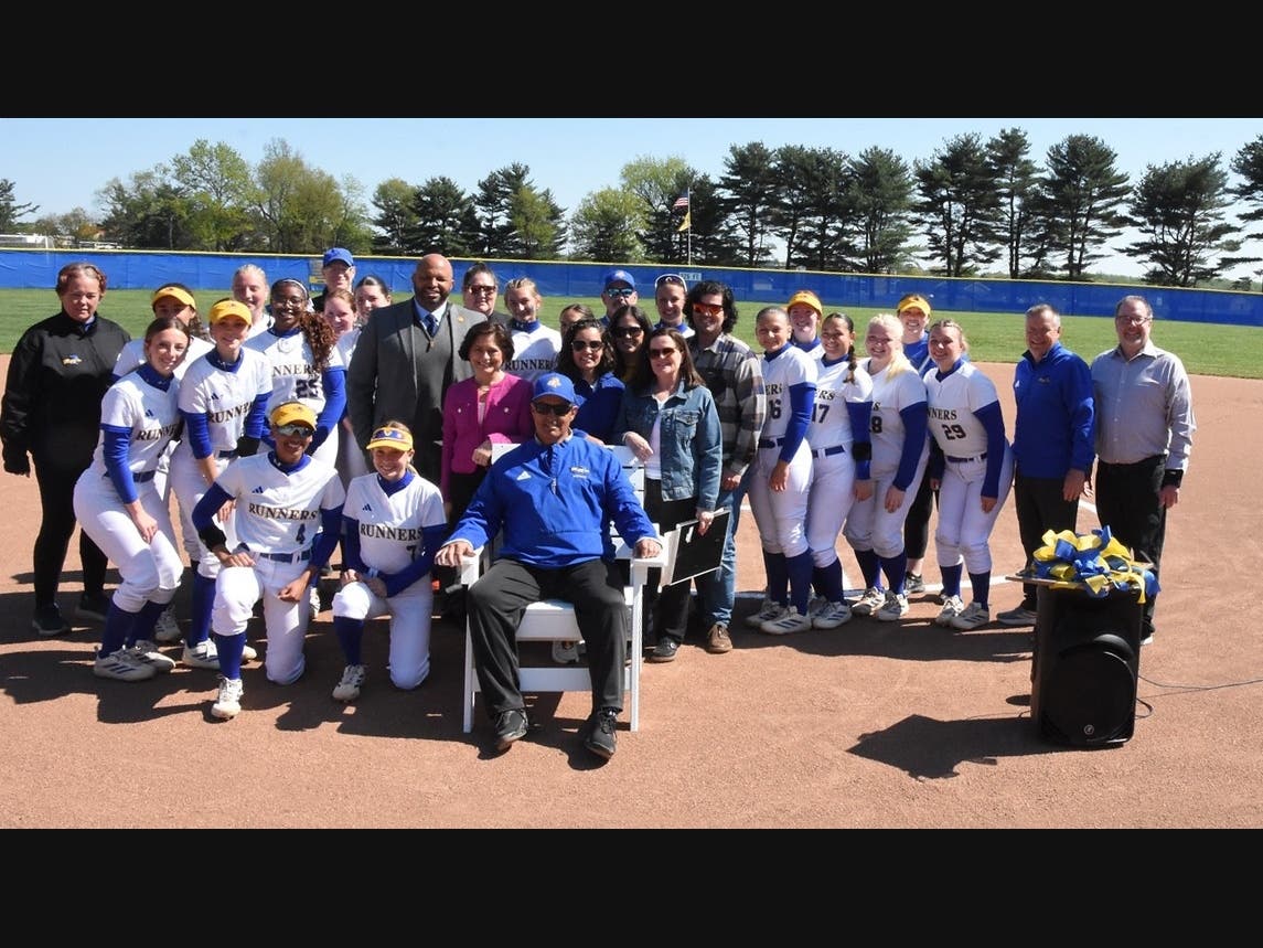 Rowan College of South Jersey–Gloucester Roadrunners Softball Coach, Steven DePasquale (seated), is surrounded by his family, team, colleagues and Gloucester County politicians to celebrate the coach’s accomplishments at his retirement ceremony. ​