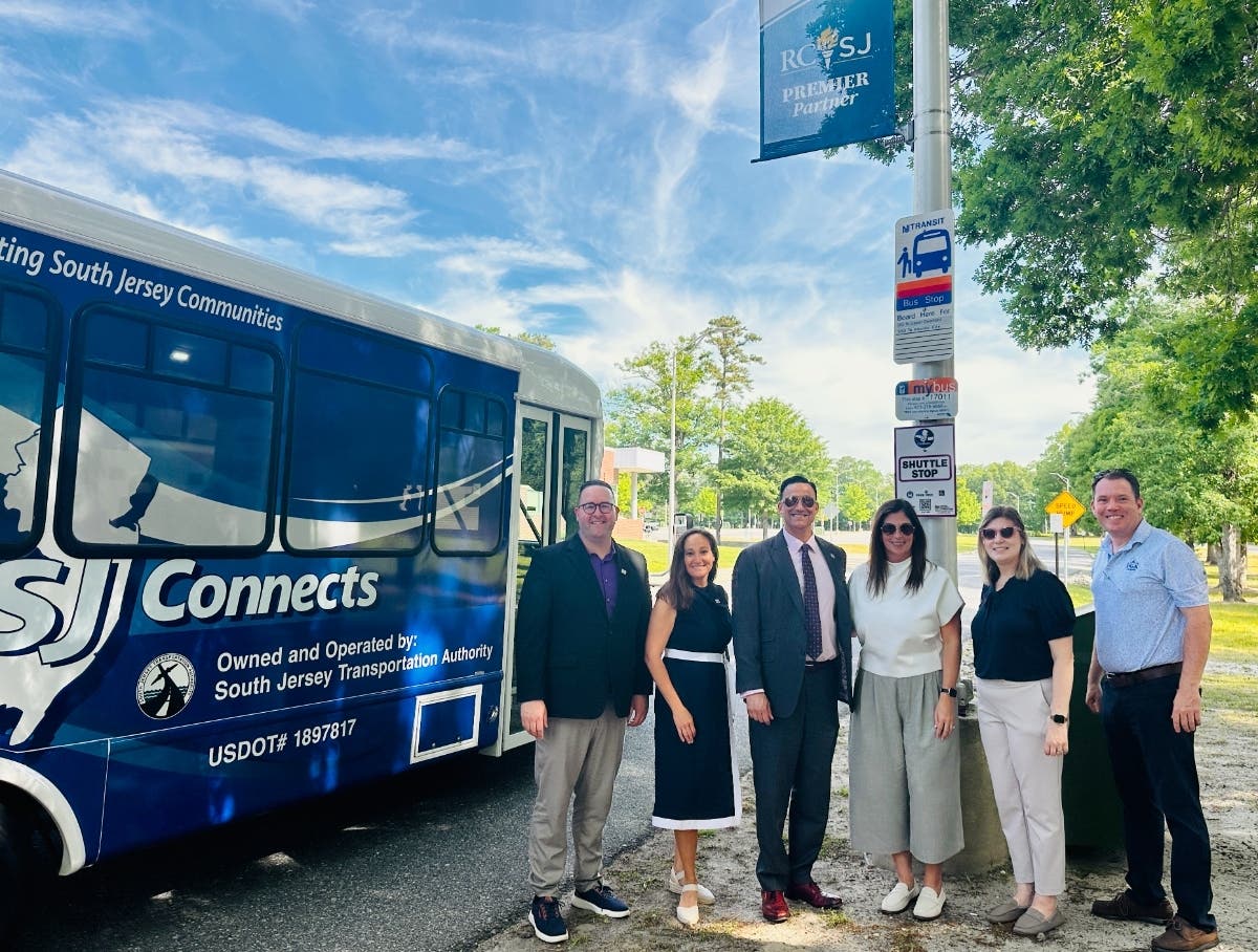 New Jersey state officials, Chamber of Commerce, SJTA and RCSJ representatives pose at an RCSJ–Cumberland bus stop next to a SJ Connects shuttle.