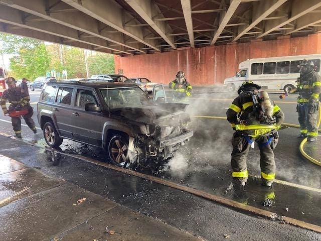 Firefighters extinguish a vehicle fire under the Route 15 overpass on Dixwell Avenue on Tuesday in Hamden.