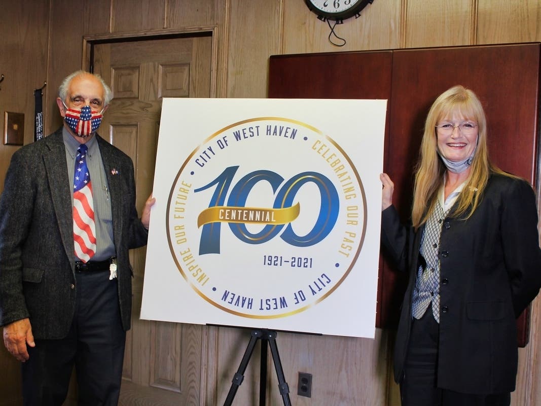 Mayor Nancy R. Rossi and her executive assistant, Louis P. Esposito Jr., reveal the logo Tuesday for West Haven’s centennial celebration in 2021.