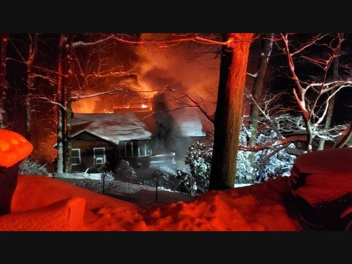 Crews extinguished a house fire during a snowstorm that left 18 inches of snow on the ground.