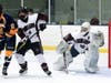 North Haven's Owen Quick (#4) stays on his man while goaltender Andrew Saco follows the puck.