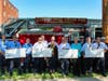 Members of West Haven’s bravest show the four FEMA checks with DeLauro and Rossi. 