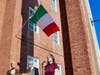 An Italian flag blows in the wind as Liz Levy sings the Italian national anthem, “II Canto degli Italiani.” Looking on are Mayor Nancy R. Rossi and Executive Assistant Louis P. Esposito Jr. Levy also sang “The Star-Spangled Banner.” 