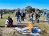 West Haven Fire Department firefighter/paramedic Jeremiah Carrier helps his daughter, Remy, 3, spray liquid on a controlled fire to put it out. Leading the fire extinguisher demonstration is UNH Fire Science Club member Sam Manuel (holding remote).