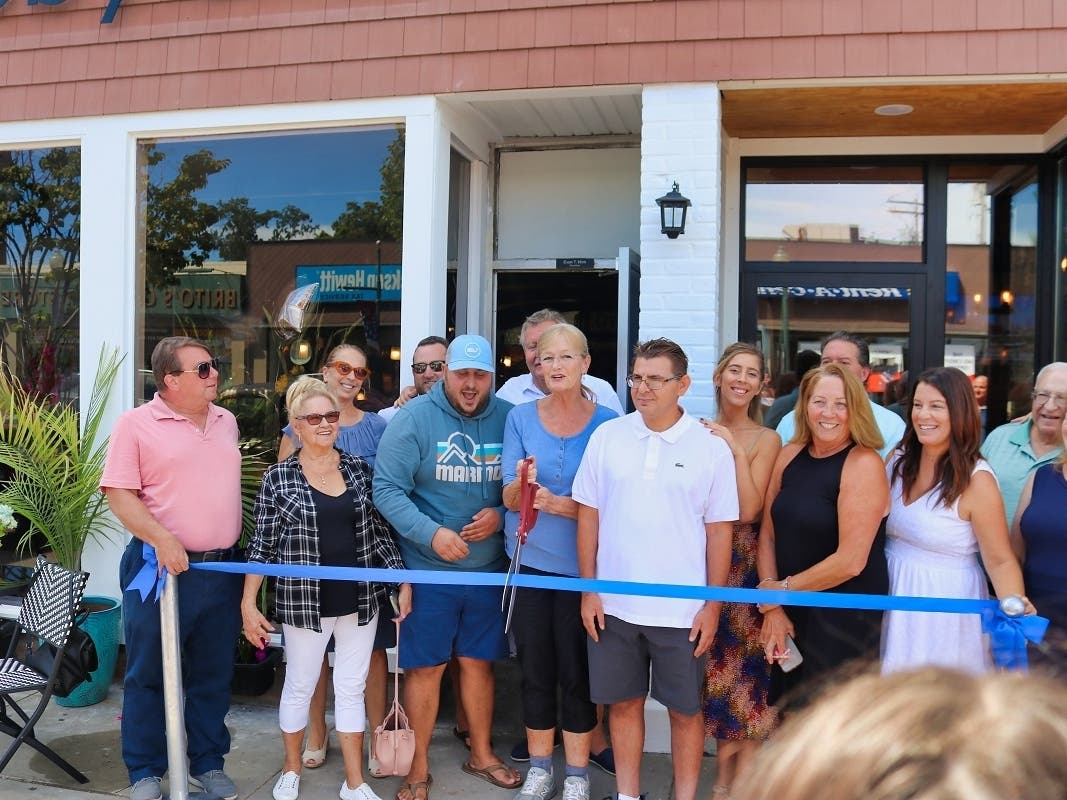 West Haven Mayor Nancy R. Rossi cuts the ribbon with Moby Dick’s owners Evan Mink, back, fourth from left, and Doug “the Rake” Ruickoldt, back, fifth from left, on Saturday to celebrate the grand opening of the “raw bar cafe” at 560 Campbell Ave. 