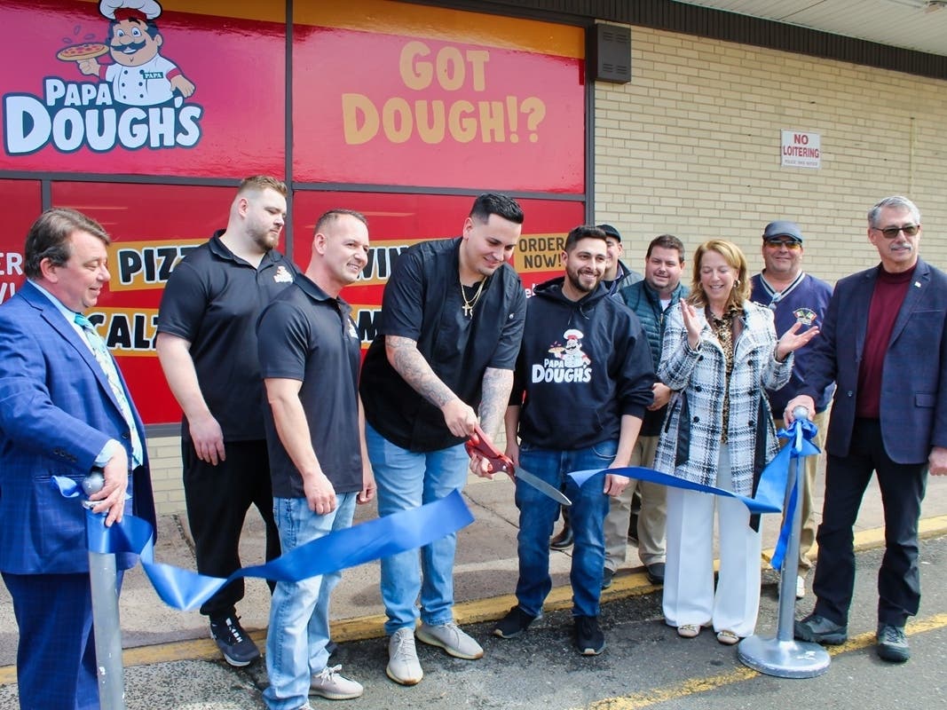 West Haven Mayor Dorinda Borer, right, claps as Papa Dough’s co-owner Pasquale Villano, center, cuts the ribbon to mark the West Haven pizzeria’s grand opening in West Shore’s Woodlawn Shopping Center at 845 Jones Hill Road on Wednesday.