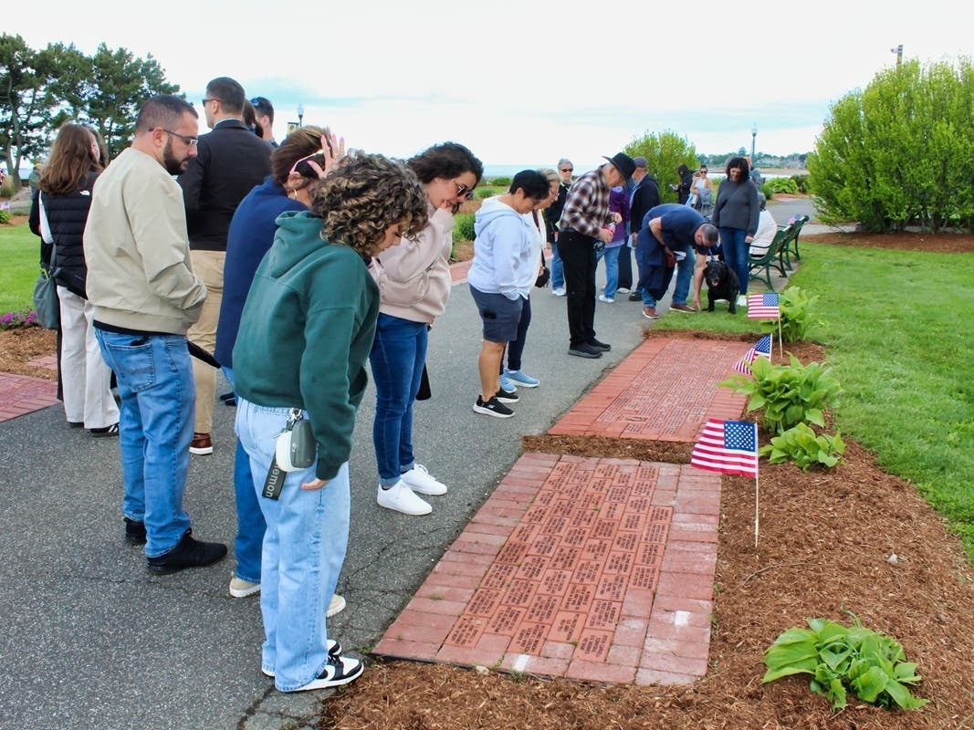 People line the Veterans Walk of Honor in West Haven’s Bradley Point Park to search for bricks purchased in honor of loved ones, both living and deceased, during the city’s Phase 17 dedication of the Walk of Honor on May 24, 2025.