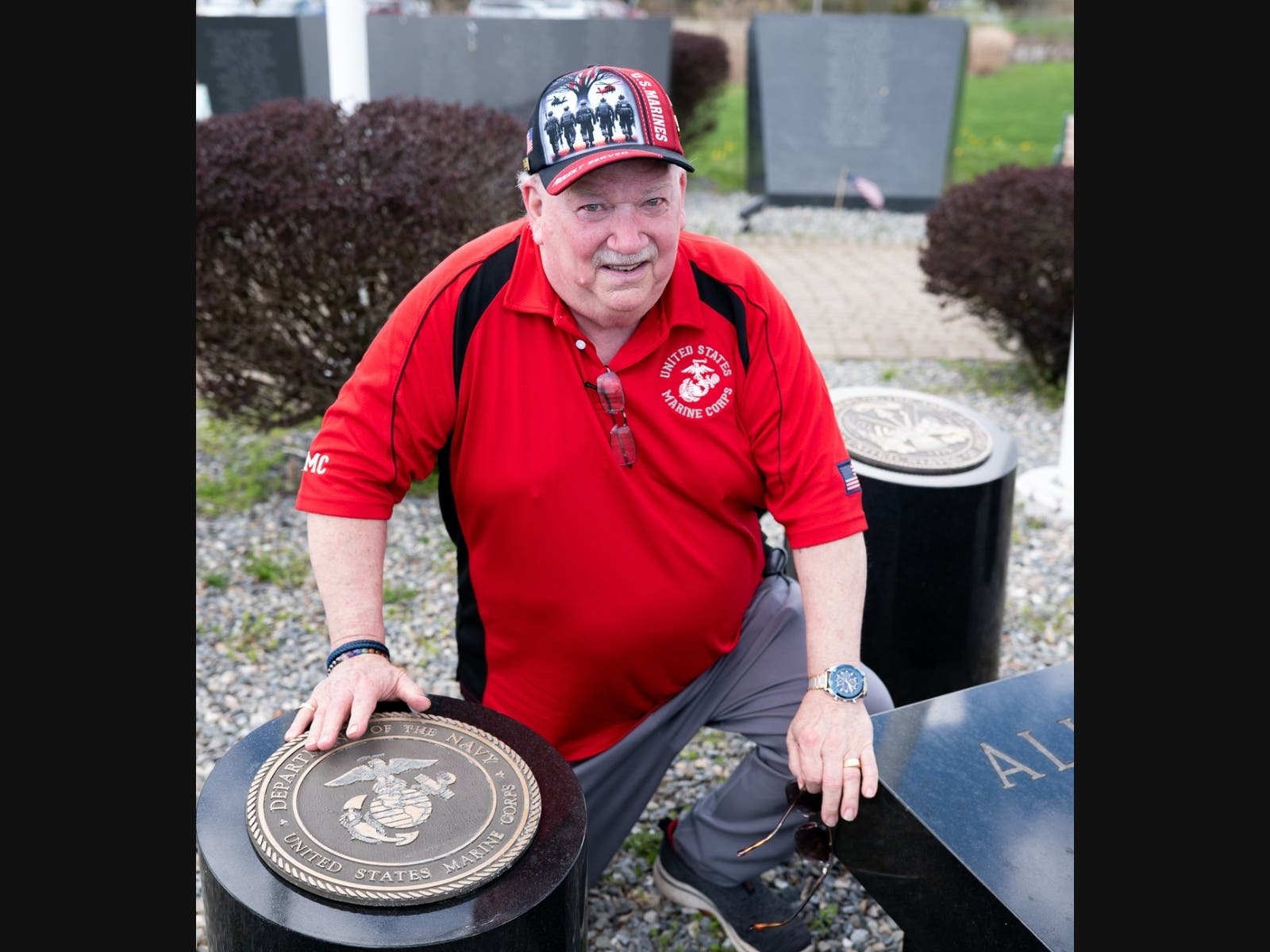 Marine Corps veteran George “Butch” Treat kneels beside the granite U.S. Marine Corps insignia at the West Haven Vietnam Veterans Memorial in Bradley Point Park on April 17.