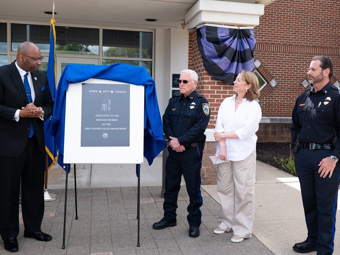 From left, West Haven Police Memorial Monument Committee Chairman Steven R. Mullins and Police Chief Joseph S. Perno unveil the design of the West Haven Police Memorial on Friday as Mayor Dorinda Borer and Deputy Chief Joseph Romano look on.