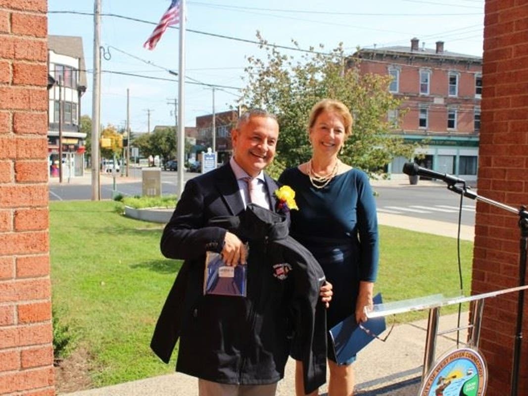 2026 West Haven Hispanic American of the Year Juan Carlos Arbeláez, the owner of Saocco Colombian Restaurant, receives an embroidered jacket and a Colombian flag from Mayor Dorinda Borer at the city’s eighth annual Hispanic Heritage Celebration.