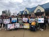 Students hold up signs sharing their thoughts on what will happen to the Toms River Regional School District if funding isn't restored. 