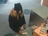 A surveillance photo shows the bank robber handing a note over at a Toms River bank Thursday. 