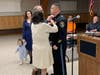 Police Chief Matthew J. Kline has some of his chief's insignia pinned on his uniform by his parents.